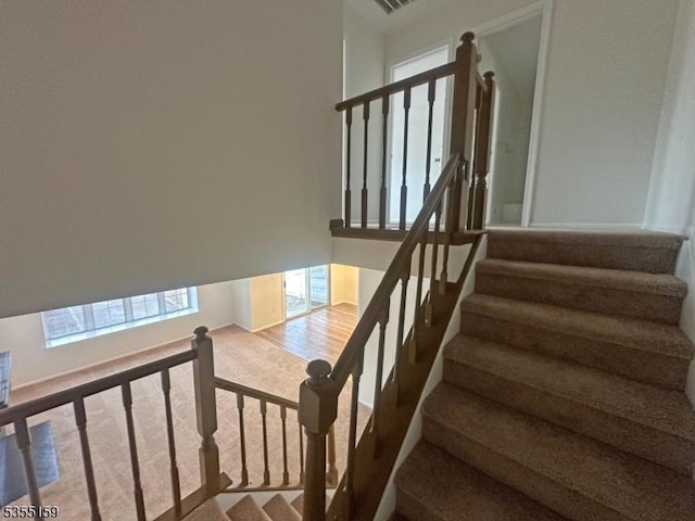 staircase featuring carpet floors and a wealth of natural light