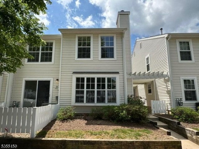 back of house with a pergola and a chimney