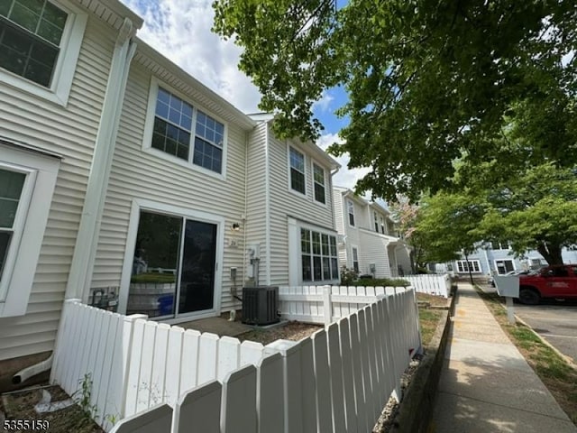 back of house featuring fence and cooling unit
