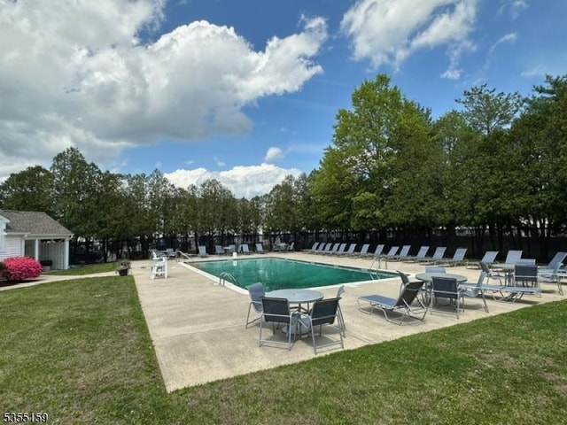 community pool featuring a patio area, fence, and a yard
