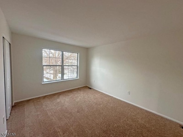 unfurnished bedroom with carpet flooring, baseboards, and a closet