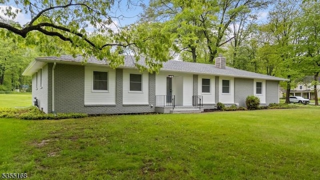 23 Woodland Dr, Washington Twp, NJ 07853 - view of front of property featuring brick siding, a chimney, and a front lawn