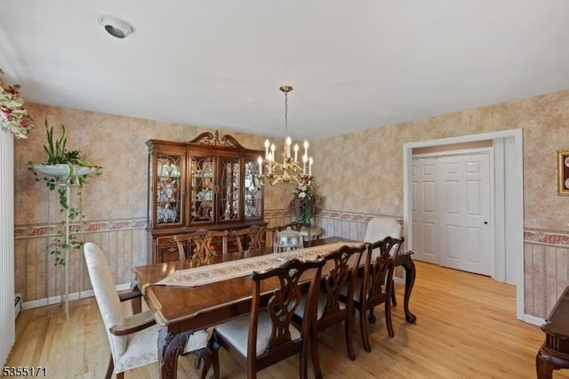 581 Montgomery Rd, Hillsborough Twp, NJ 08844 - dining space with baseboard heating, light wood-style floors, a chandelier, a wainscoted wall, and wallpapered walls
