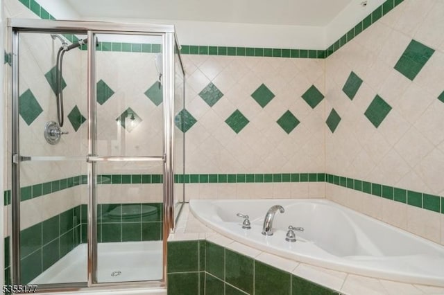 full bath featuring a garden tub and a shower stall