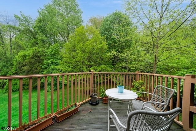 wooden terrace featuring a lawn