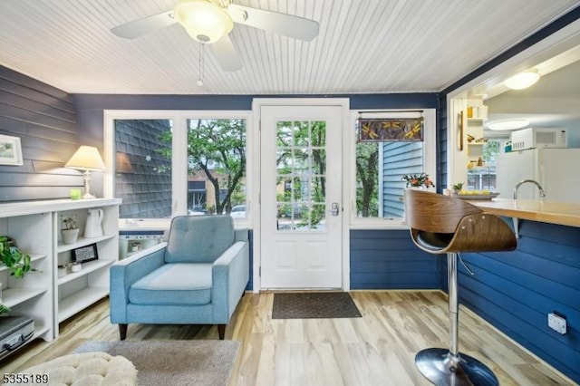 sitting room with wood finished floors, ceiling fan, and wooden ceiling