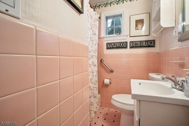 full bath with toilet, tile walls, vanity, tile patterned floors, and curtained shower