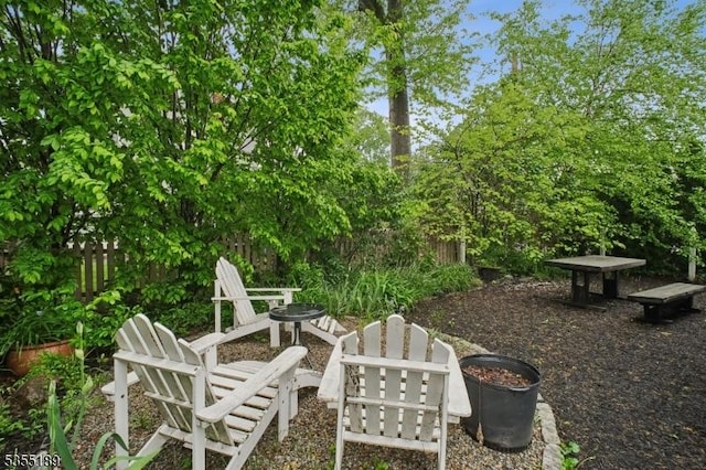 view of patio featuring an outdoor fire pit and fence