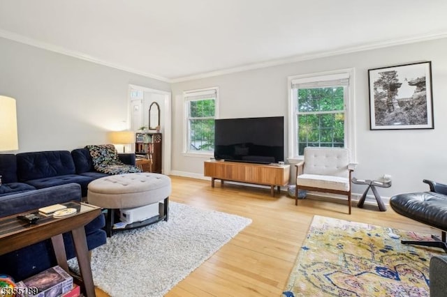 living area with crown molding, wood finished floors, and baseboards