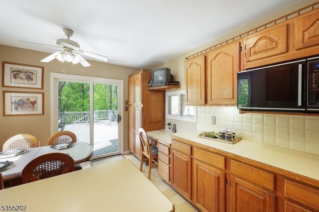 kitchen featuring light countertops, black microwave, a wealth of natural light, and tasteful backsplash
