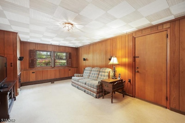 living room with wood walls and light colored carpet