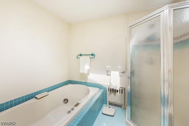 full bath with a tub with jets, radiator heating unit, tile patterned flooring, and a stall shower