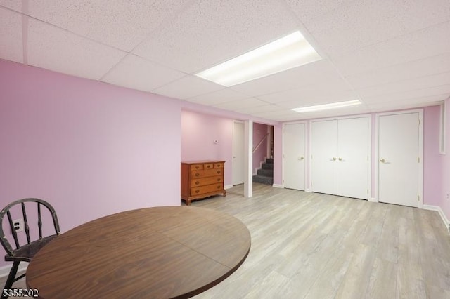 bedroom featuring light wood-style floors and a drop ceiling