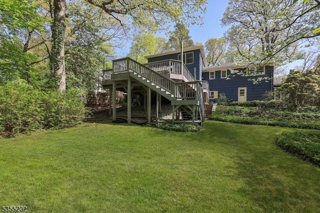 rear view of house with a lawn, a deck, and stairs