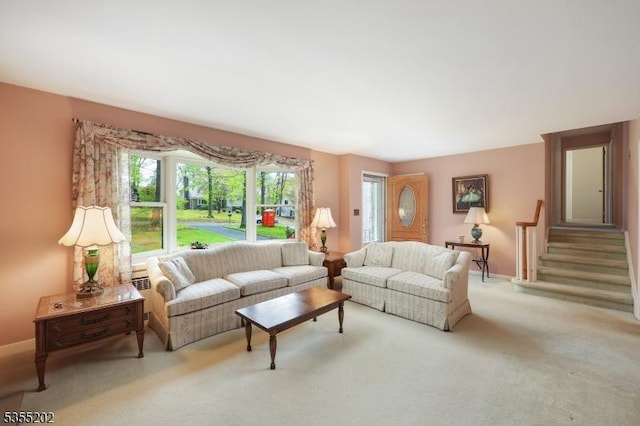 carpeted living area with baseboards and stairway