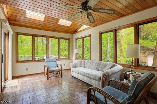 sunroom / solarium with baseboards, wooden ceiling, a wealth of natural light, and vaulted ceiling with skylight