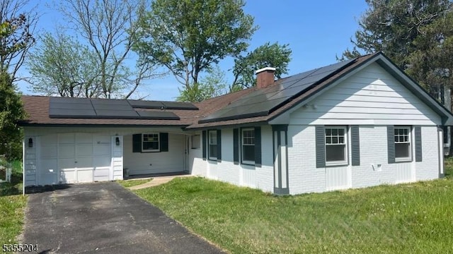 151 Pageant Ln, Willingboro Twp, NJ 08046 - view of front of property featuring an attached garage, a chimney, asphalt driveway, and roof mounted solar panels