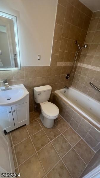 151 Pageant Ln, Willingboro Twp, NJ 08046 - bathroom featuring tile walls, tile patterned floors, vanity, toilet, and tiled shower / bath