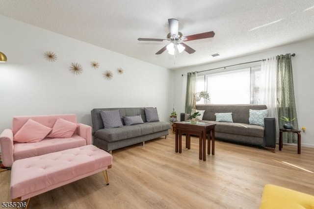 living area with light wood finished floors and ceiling fan
