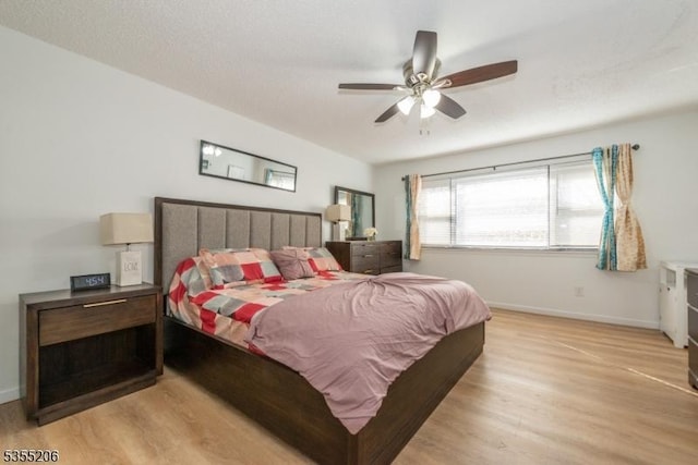 bedroom featuring baseboards, ceiling fan, and light wood-style flooring