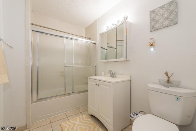 bathroom with tile patterned flooring, vanity, toilet, bath / shower combo with glass door, and a textured ceiling