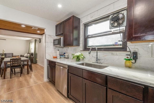kitchen featuring tasteful backsplash, light wood-type flooring, a sink, stainless steel appliances, and recessed lighting