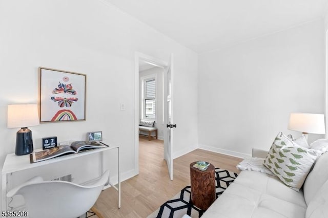 living area featuring baseboards and light wood-type flooring
