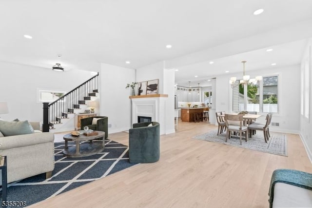living area featuring light wood finished floors, stairs, and a wealth of natural light