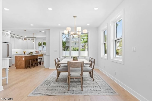 dining room featuring an inviting chandelier, recessed lighting, light wood-style flooring, and baseboards