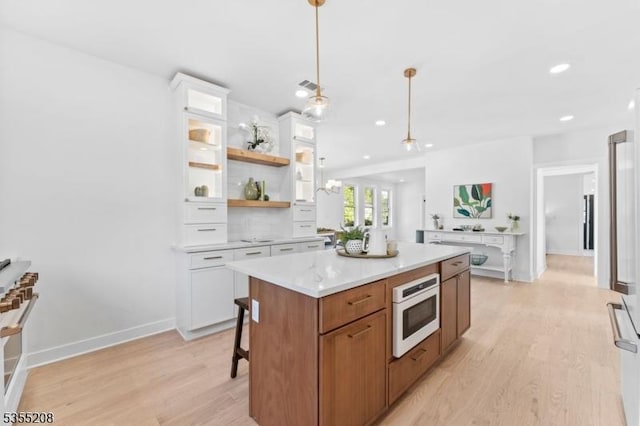 kitchen with open shelves, light wood finished floors, white cabinets, and light countertops