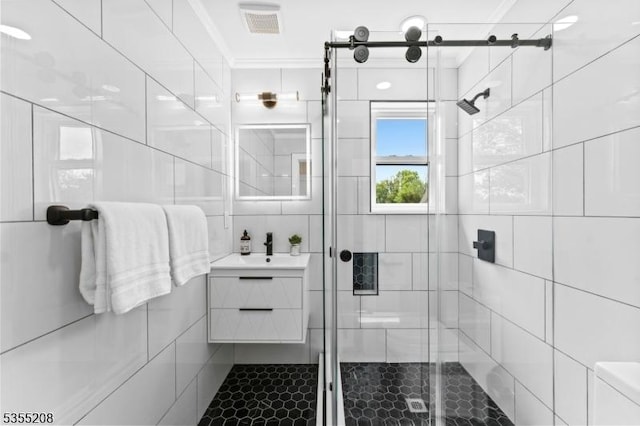 full bathroom featuring visible vents, tile walls, a stall shower, vanity, and ornamental molding