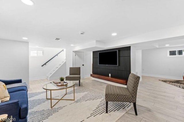 living area featuring recessed lighting, baseboards, stairway, and light wood-type flooring