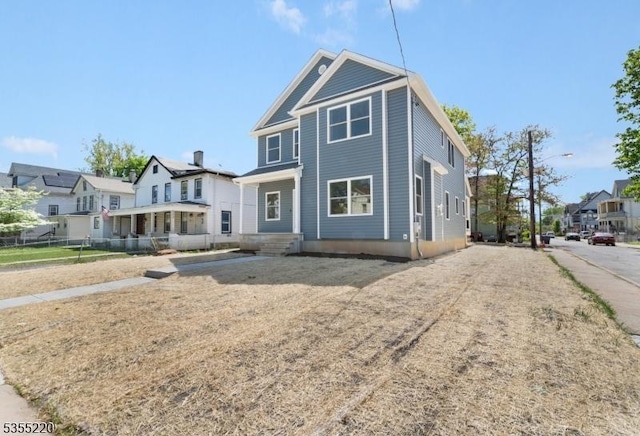 view of front of home featuring fence and a residential view