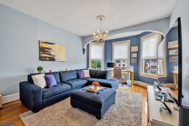 152 Main St, Flemington Boro, NJ 08822 - living area with arched walkways, radiator, wood finished floors, and a chandelier