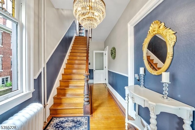 152 Main St, Flemington Boro, NJ 08822 - stairway with radiator heating unit, a chandelier, wood finished floors, and baseboards