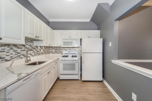 kitchen featuring white appliances, a sink, white cabinetry, ornamental molding, and light stone counters