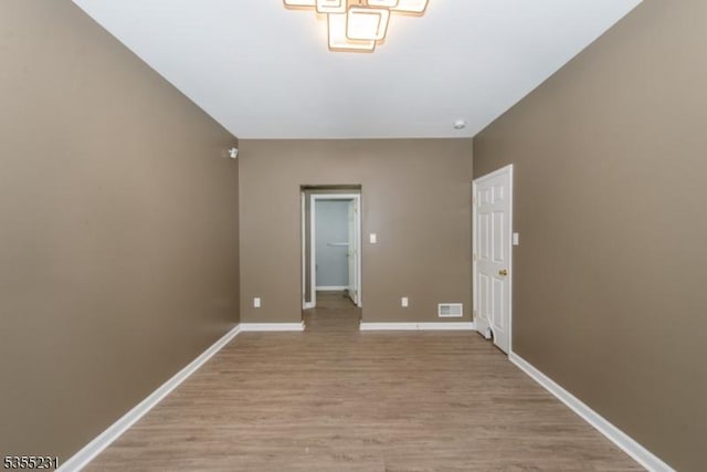 spare room featuring light wood-style floors and baseboards