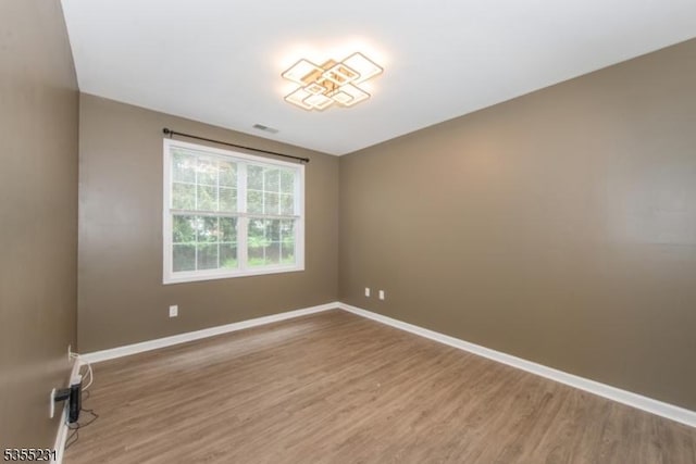 unfurnished room featuring wood finished floors and baseboards