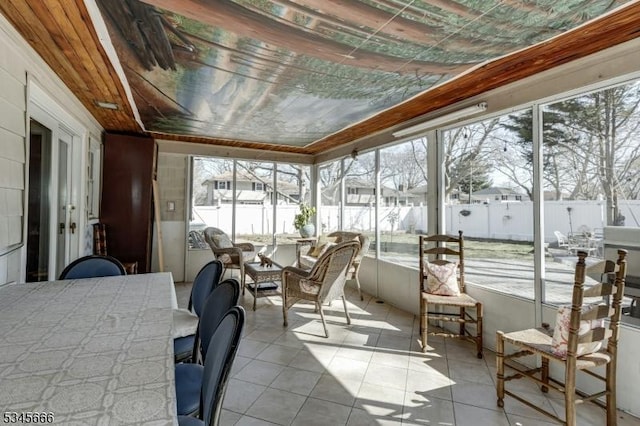 sunroom / solarium featuring outdoor dining area and tile patterned floors