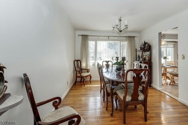 dining area with an inviting chandelier, light wood-style flooring, and baseboards