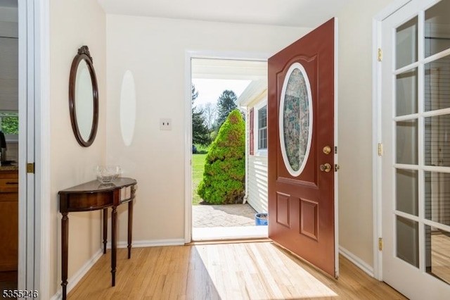 foyer featuring baseboards and light wood-type flooring