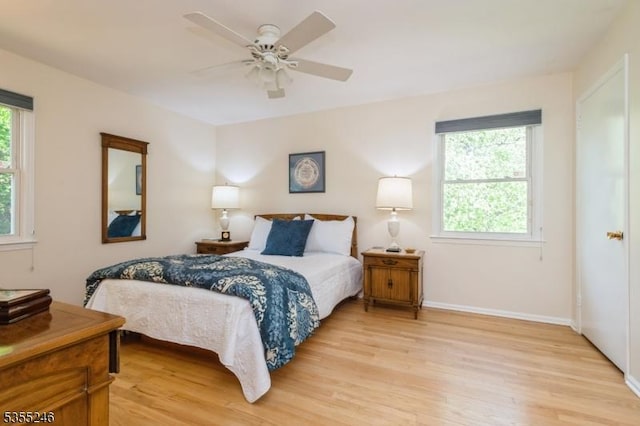 bedroom featuring a ceiling fan, baseboards, and light wood finished floors