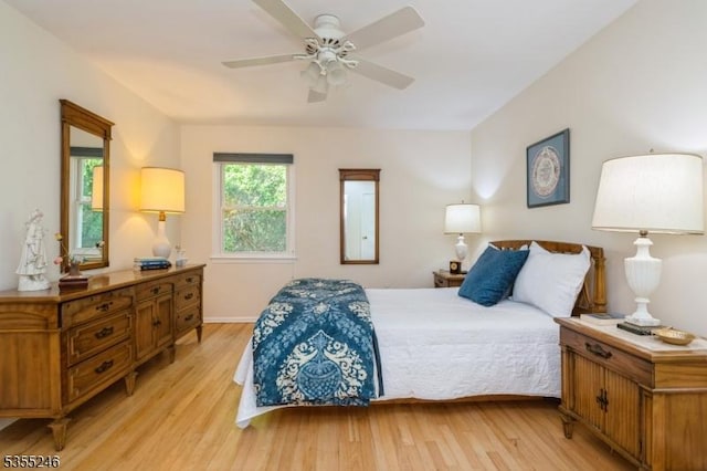 bedroom with baseboards, ceiling fan, and light wood-style flooring