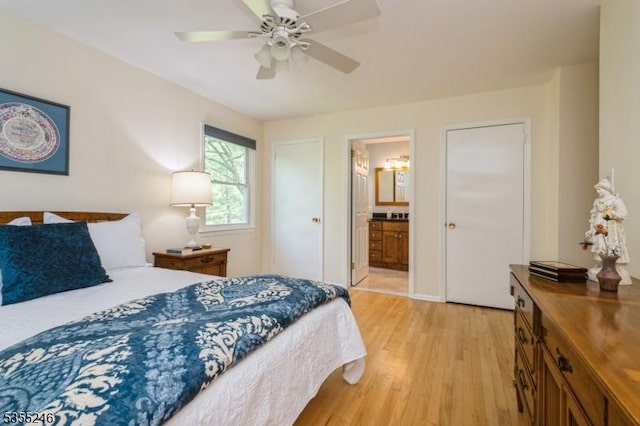 bedroom featuring a ceiling fan, ensuite bath, and light wood-style flooring
