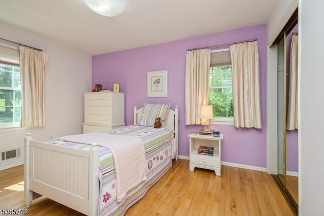 bedroom featuring baseboards, visible vents, and light wood-style flooring