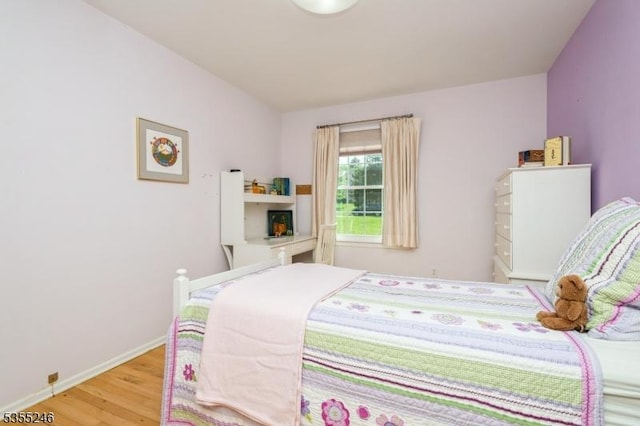 bedroom featuring baseboards and wood finished floors