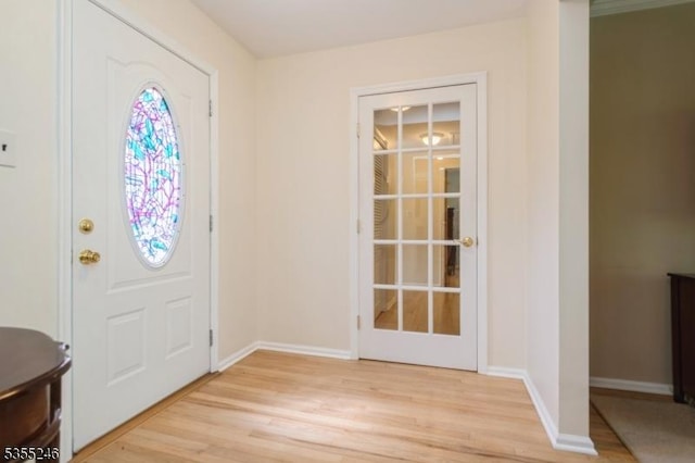 foyer featuring baseboards and light wood-type flooring