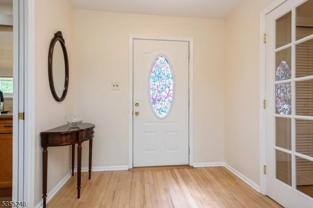 foyer entrance featuring baseboards and light wood-style flooring