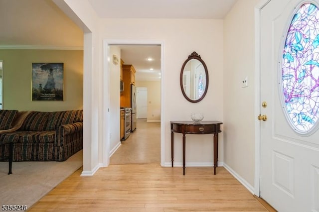 foyer featuring light wood-style floors and baseboards
