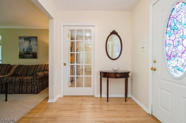 foyer with baseboards and light wood-type flooring